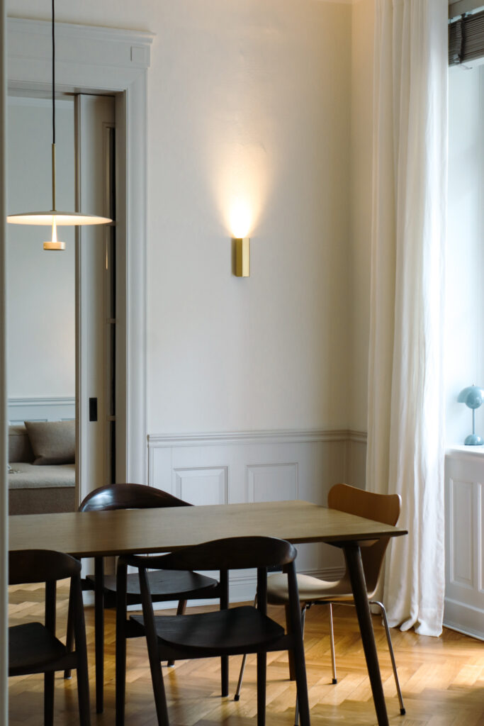 Wohnzimmer einer sanierten Altbauwohnung mit Blick auf Essbereich